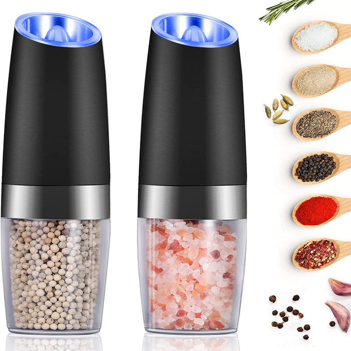 Götze Electric Salt & Pepper Grinder Set with clear spice chambers, stainless steel accents, and illuminated grinding tops, shown with assorted seasonings.