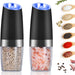 Götze Electric Salt & Pepper Grinder Set with clear spice chambers, stainless steel accents, and illuminated grinding tops, shown with assorted seasonings.