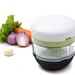 Götze Fresh Mavo manual food chopper with clear container, white lid, green blade system, and black non-slip base displayed beside lettuce, carrot, onion, and garlic.