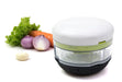 Götze Mavo manual food chopper with clear container, white lid, green blade system, and black non-slip base displayed with fresh vegetables.