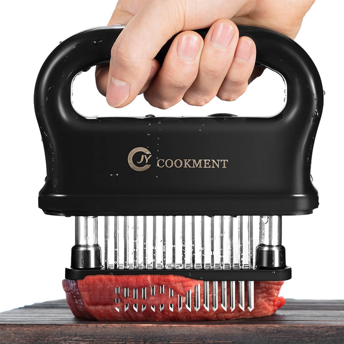 Black 48-blade stainless steel meat tenderizer being pressed into raw meat to pierce and tenderize it evenly.