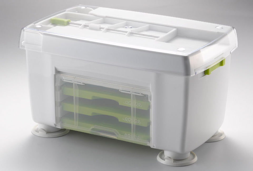 Götze Premium Vegetable Spiralizer storage base with clear protective lid, suction feet, and built-in compartment for organizing interchangeable grater attachments.