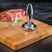 Götze Reversible Dual-Sided Meat Tenderizer & Pounder displayed on a wooden cutting board beside a raw steak and fresh rosemary.