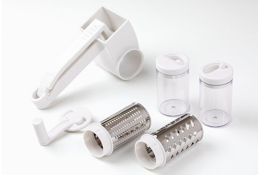 Götze rotary grater set with hand crank, two interchangeable stainless steel grating drums, and two clear storage containers on a white background.