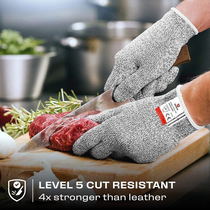 Premium Cut Resistant Glove worn while slicing raw meat with a chef knife, providing hand protection during food preparation.